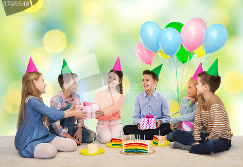 Image of happy children giving presents at birthday party