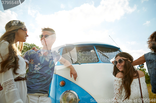 Image of smiling young hippie friends over minivan car