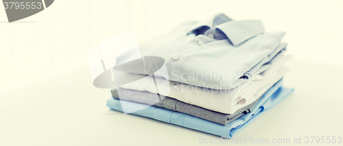 Image of close up of ironed and folded shirts on table