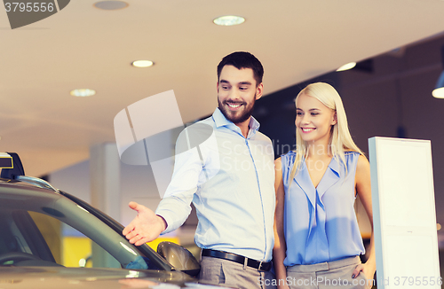 Image of happy couple buying car in auto show or salon