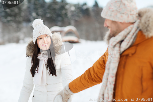 Image of happy couple walking along snowy winter field