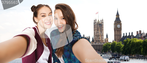 Image of happy teenage girls taking selfie in london