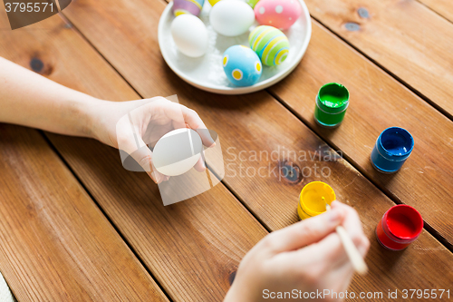 Image of close up of woman hands coloring easter eggs