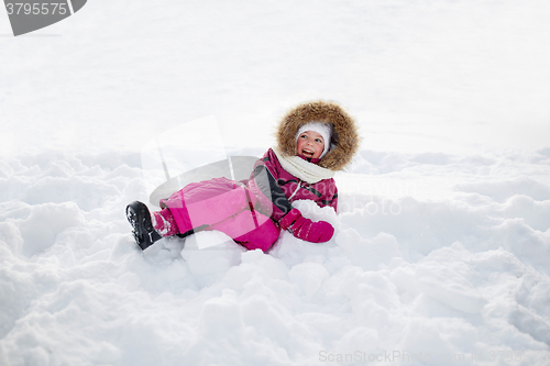 Image of happy little kid or girl in winter clothes on snow