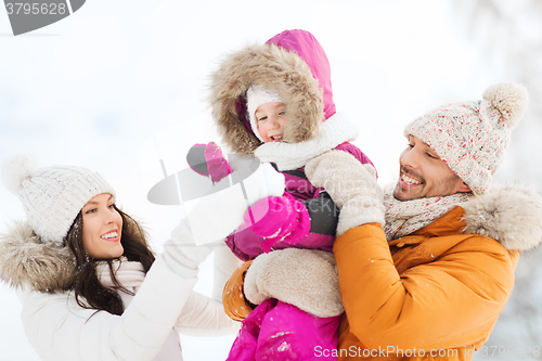 Image of happy family with child in winter clothes outdoors