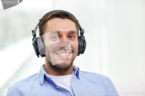 Image of smiling young man in headphones at home