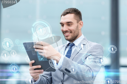 Image of smiling businessman with tablet pc outdoors