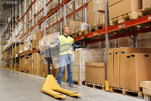 Image of man with loader and clipboard at warehouse