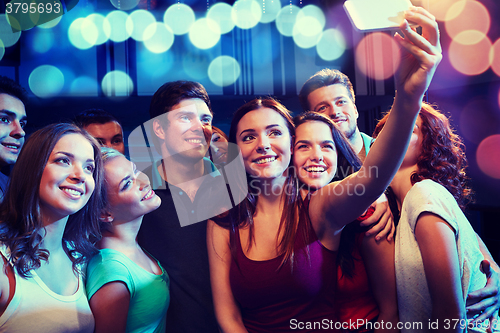 Image of friends with smartphone taking selfie in club