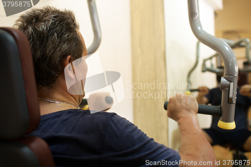 Image of Man exercising on shoulder press machine