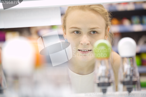 Image of Young woman analyzing products in a store