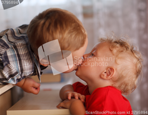 Image of Cute siblings. Two little brothers are kissing.