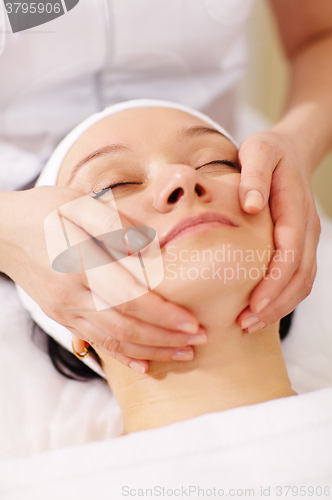 Image of Woman in the beauty spa getting a facial massage