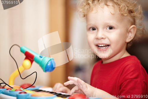 Image of Adorable little boy playing with a toy microphone