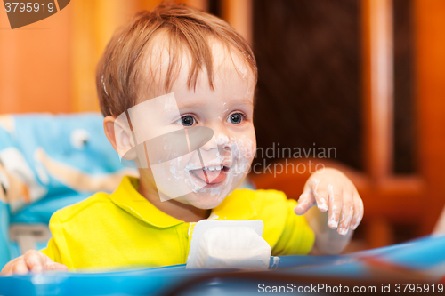 Image of Happy child dirty with cream yoghurt