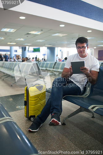 Image of Young man using touch pad in the airport lounge