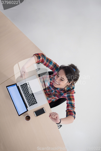 Image of top view of young business woman working on laptop