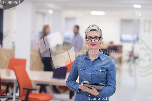 Image of portrait of young business woman at office with team in backgrou