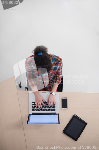 Image of top view of young business woman working on laptop