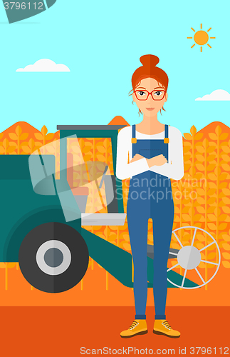 Image of Woman standing with combine on background.