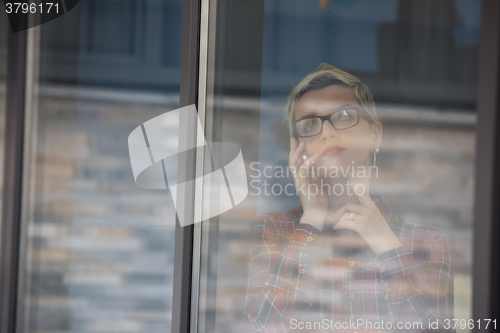 Image of business woman in meeting room  speaking by cell phone
