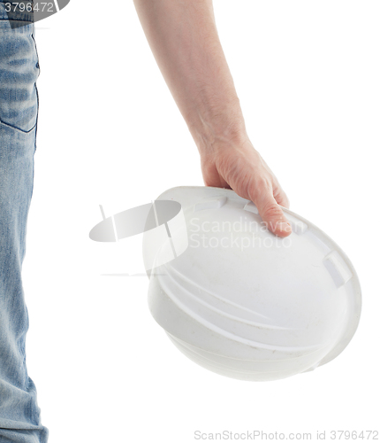 Image of Male engineer in jeans holding white hardhat