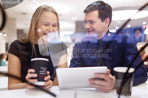 Image of Woman laughs as man shows tablet