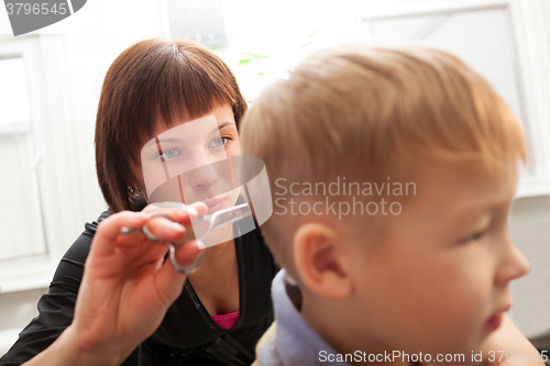 Image of Hairdresser trimming a small boys hair