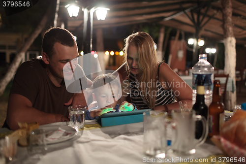 Image of Parents and child with tablet PC in outdoor cafe