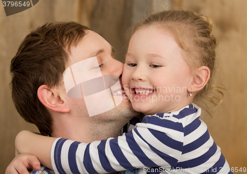 Image of Happy father kissing little daughter