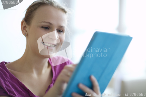 Image of Young woman smiling as she surfs the internet