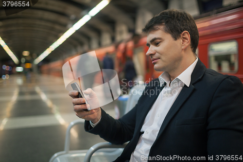 Image of Businessman with smartphone in subway