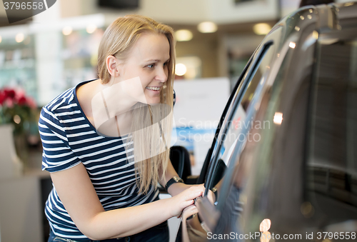 Image of Woman admiring a car at an auto show