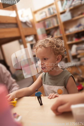 Image of Little boy playing with toys in the room