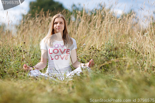 Image of Young girl meditating in the field