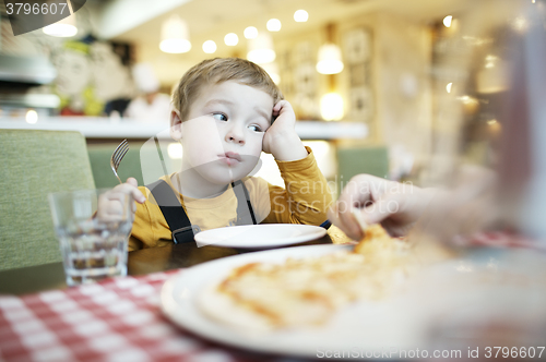 Image of Bored little boy in a restaurant