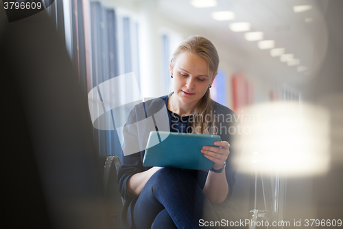 Image of Young woman with pad in the waiting room