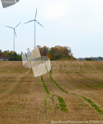 Image of Two wind turbines in the field.