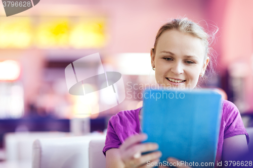 Image of Woman using tablet PC in the restaurant indoors