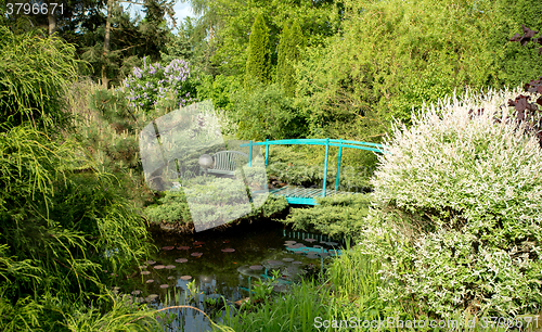 Image of small green footbridge over a pond