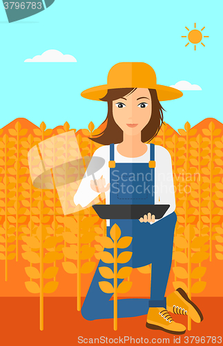 Image of Woman with tablet computer on field.