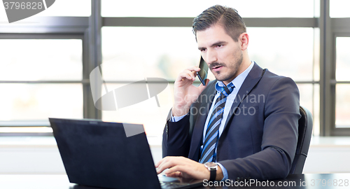 Image of Businessman in office working on laptop computer.