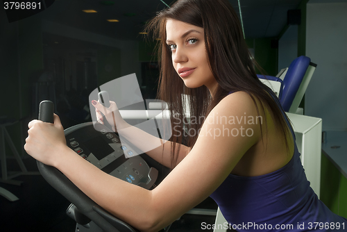 Image of Smiling woman on a bicycle simulator