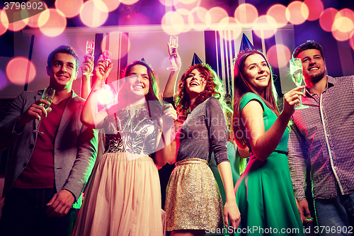 Image of smiling friends with glasses of champagne in club