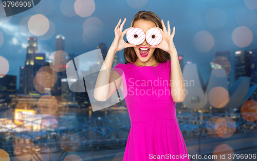 Image of happy woman or teen girl looking through donuts