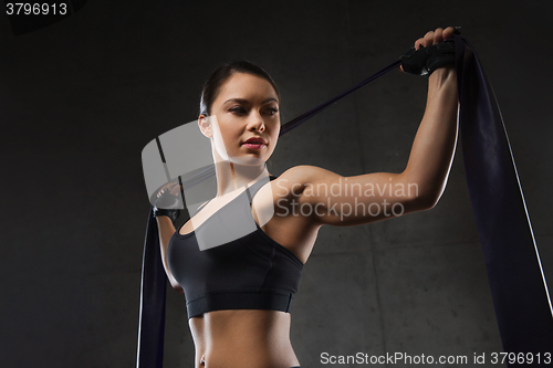 Image of woman with expander exercising in gym