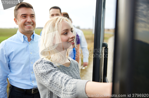 Image of group of happy passengers boarding travel bus