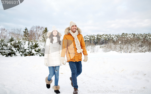 Image of happy couple walking along snowy winter field