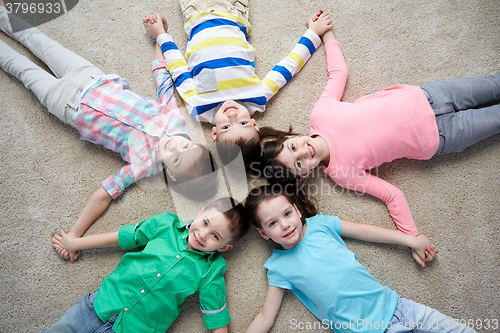 Image of happy smiling little children lying on floor