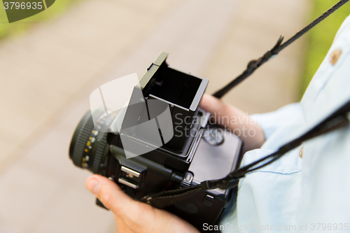 Image of close up of male photographer with digital camera